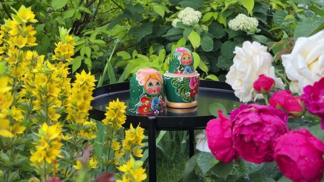 Matryoshka Dolls in a Garden Setting: Traditional Russian nesting dolls, intricately painted with charming faces and vibrant attire, are displayed amidst a lush.