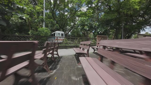 Low angle FPV view flying fast through empty audience seating at an outdoor public theater park in Taiwan
