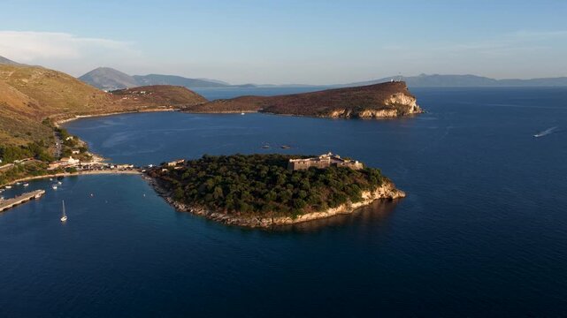 Aerial view of Porto Palermo Castle situated on a lush green peninsula surrounded by the deep blue waters of the Ionian Sea in Porto Palermo, Qarku i Vlores, Albania.