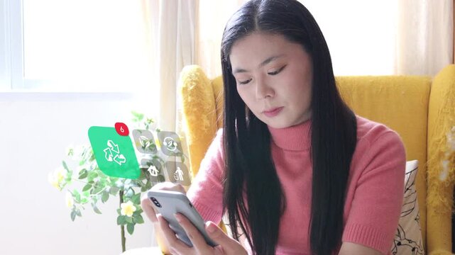 Asian woman uses smartphone on armchair to track eco environment status, highlighted by a 3D tracked green sorting recycling loop and reuse notification pop ups.