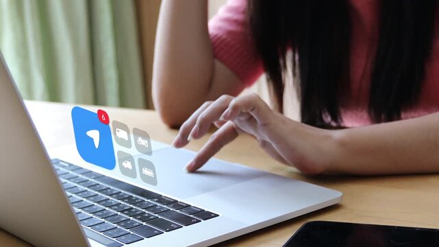 Adult Asian woman typing on a laptop computer, with a 3D tracked location arrow navigation map badge and virtual transport vehicle delivery pop up icons.