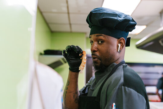 Chef Holding Shrimp in Kitchen