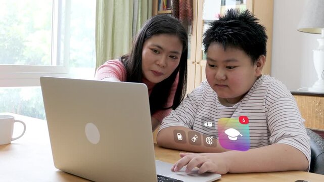 East Asian mother and her young son using a laptop together at a home workspace, featuring 3D tracked university graduation cap and school learning pop up icons.