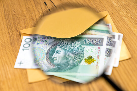 Polish banknotes in yellow envelope on wooden background