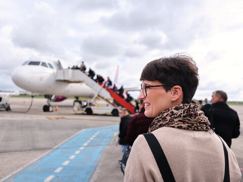 Woman smiling boarding airplane for travel in Bucharest