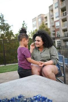 Mother connecting with toddler son outdoors at apartment courtyard