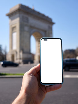 Hand holding smartphone with blank screen in Bucharest