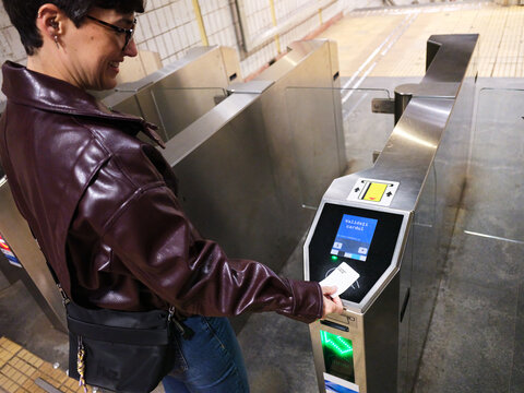 Woman validating ticket at Bucharest metro turnstile
