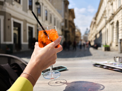 Hand holding refreshing aperitif cocktail on Bucharest street