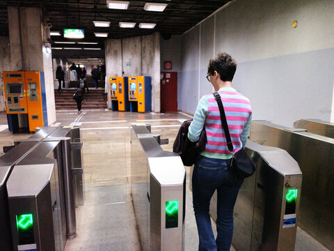 Person passing through ticket barriers at a subway station
