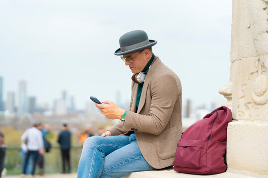 Traveler using smartphone with London skyline in background