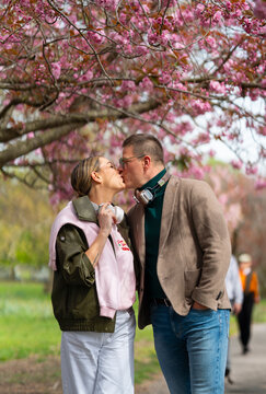 Couple kissing under cherry blossoms in Greenwich Park London