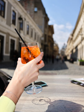 Person holding refreshing orange drink in Bucharest old town