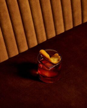 Moody Whiskey Cocktail with Orange Garnish in Elegant Lounge