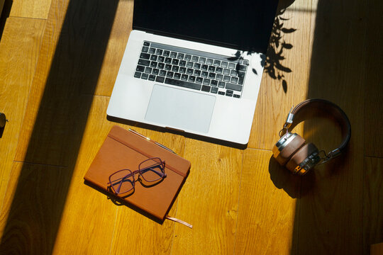 Workspace with laptop, notebook, and headphones