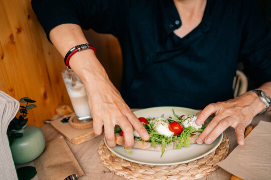 Hands Grab a Meal at a Cozy Restaurant in the Morning