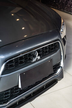 Grey Mitsubishi ASX front grille and logo, Compact SUV front end detail inside studio