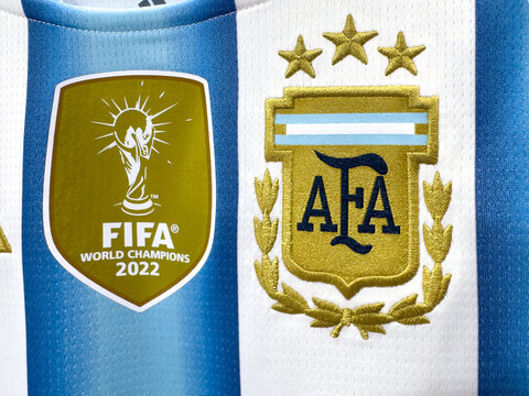 Buenos Aires, Argentina. June 18, 2026. Macro of the official AFA crest beside the FIFA World Champions 2022 badge on a soccer jersey.