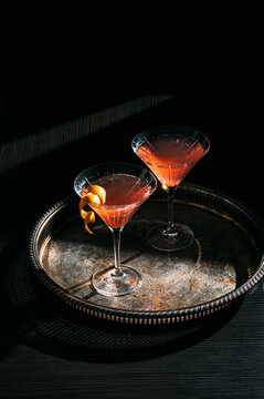 Two cocktails in martini glasses with dramatic shadows 