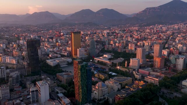 Aerial view of the modern city skyline with skyscrapers and mountains during golden hour in Tirana, Tirana County, Albania.