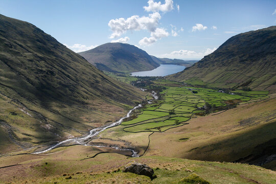 Elevated view overlooking the green patchwork fields of Wasdale valley towards distant Wastwater lake