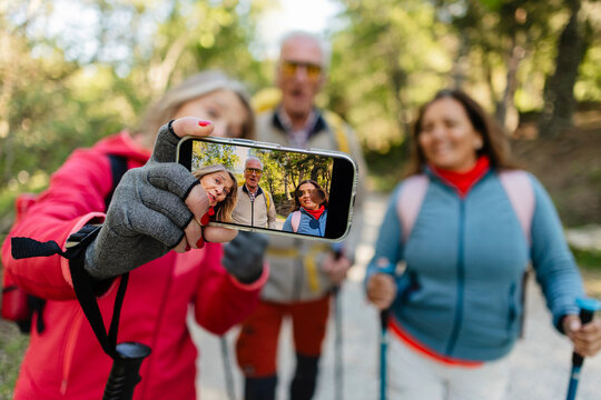 Senior friends hiking taking selfie in nature together