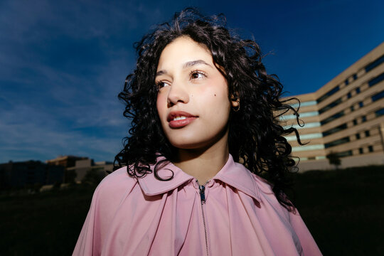 Woman with curly hair looking away outdoors