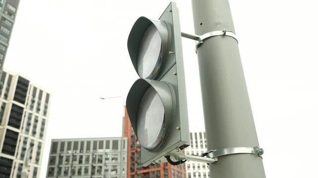Traffic light installed on city street intersection in modern urban environment with residential buildings in background