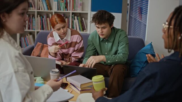 Stab shot of multiethnic teenage students collaborating on group project using laptops in library. Clip ideal for educational marketing, university recruitment, and student lifestyle campaigns