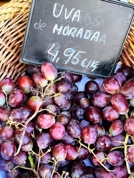unches of grapes beside a market price sign