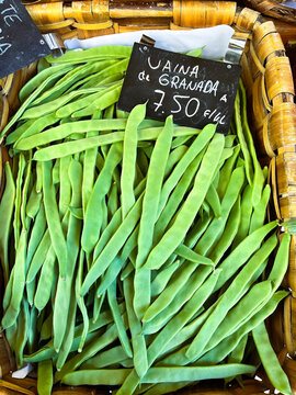 Basket of fresh flat green beans with signage