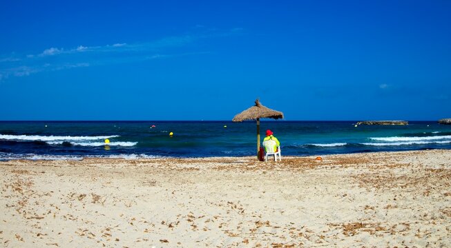 Lifeguard on the beach of Cala Moreia in the resort of S&acute;illot on the island of Mallorca in the Balearic Islands in Spain.