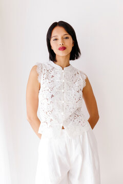 Model posing wearing white lace top