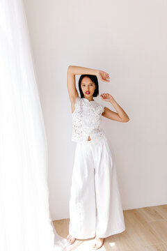 Woman n white lace and wide-leg pants