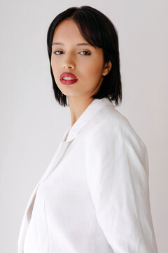 Woman posing in white blazer with red lipstick