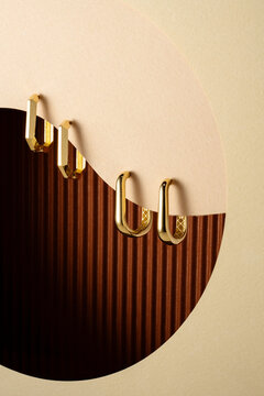 Minimalist Gold Oval Hoop Earrings on Abstract Geometric Background