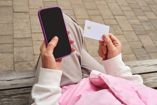 Person making online payment using smartphone and credit card
