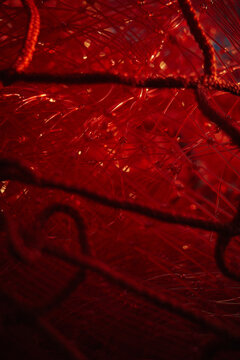 Close look at red fishing net with strands and knots in plain view