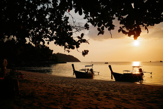 Long tail boat anchored near shore on a calm day on a Thai island