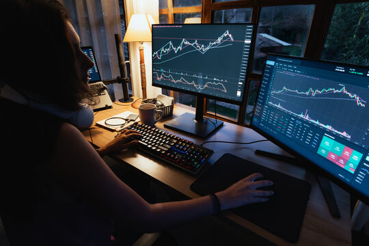 woman Trading and analysing financial Stock charts on Multiple Screens