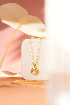 Gold Pearl Pendant Necklace on Minimalist Pedestal with Floral Accents