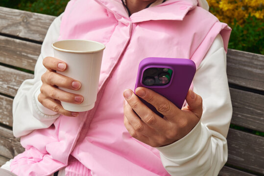 Woman drinking coffee while surfing in her smartphone