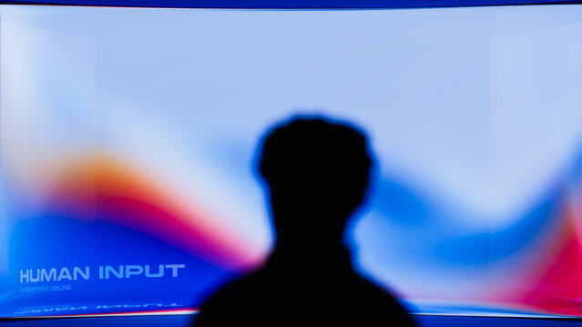 Human silhouette observes screen in a tech setting