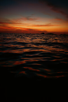 Sunset view over calm waters and distant islands near the shore