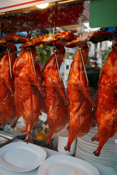 Crispy ducks hanging in a street food stall in Thailand