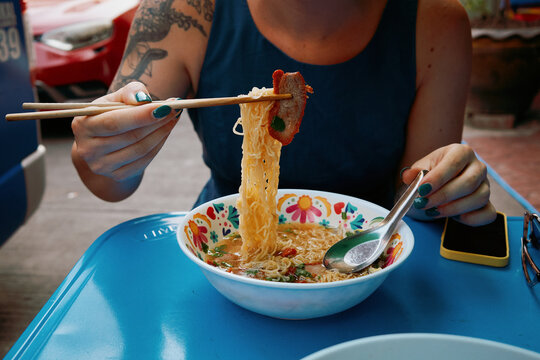 Enjoying noodles with chopsticks in a local eatery