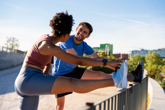 Athlete couple stretching legs outdoors before running