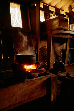 Boiling water on a wooden stove inside a rustic cabin