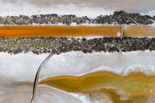 Wooden bridges and vegetation around the edges of drying salt ponds