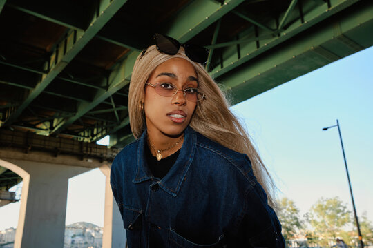 Young woman in denim jacket posing beneath bridge near Hangang River